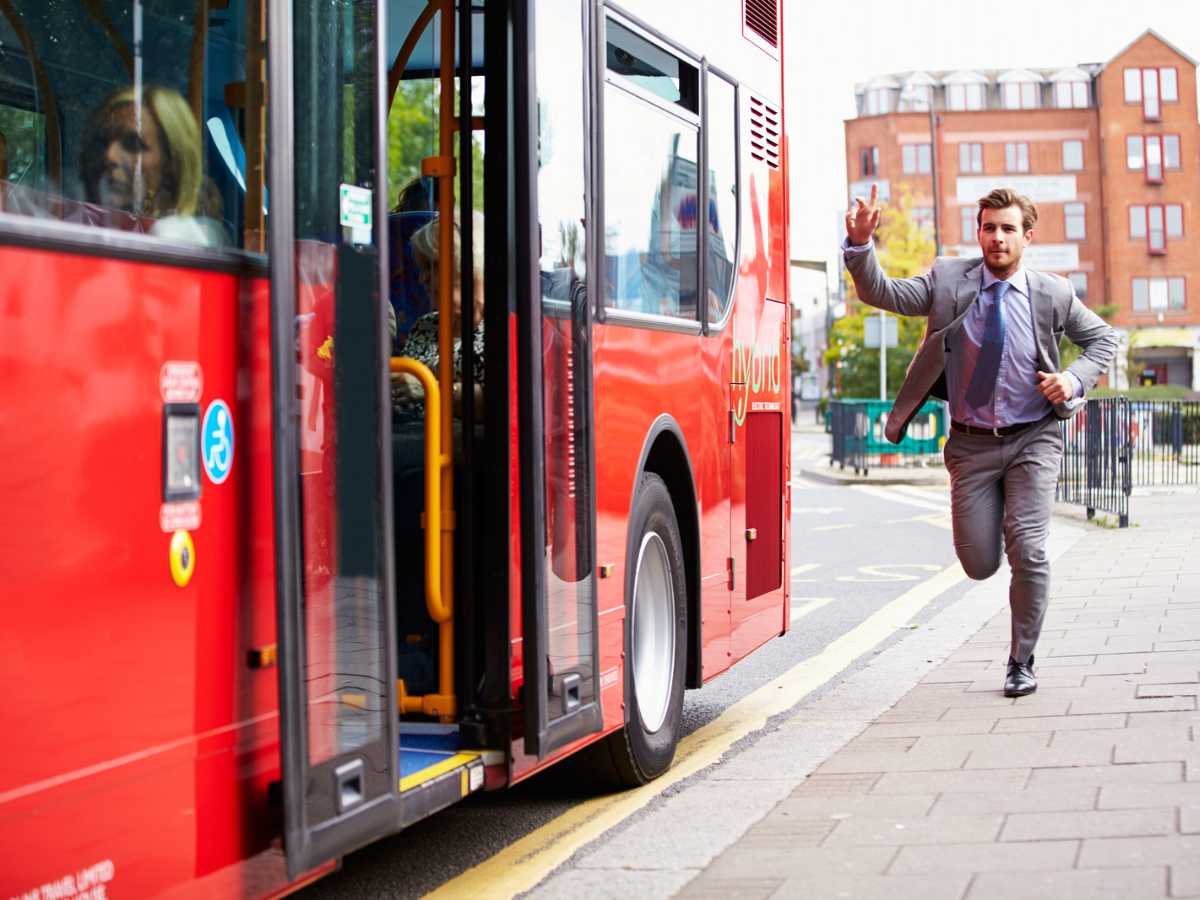 Well-dressed man chasing the bus on his way to work.