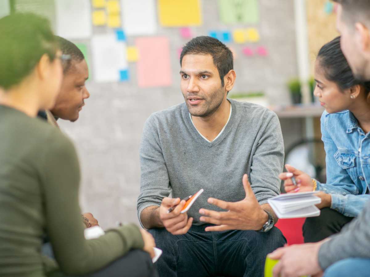 Man leading a discussion with people sharing common interests.