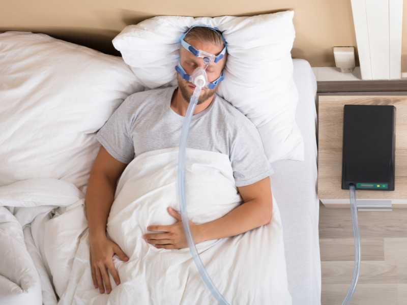 Someone with obstructive sleep apnea, or OSA, using a CPAP for treatment.